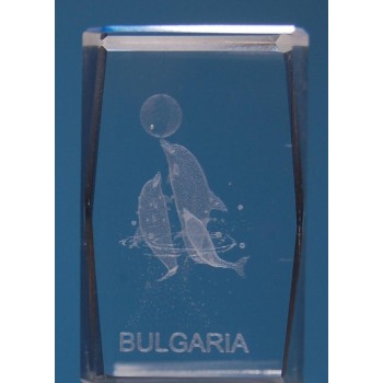 Безцветен стъклен куб с триизмерно гравирани три делфина с топка и надпис България