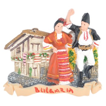 Релефна магнитна фигурка на мъж и жена в народни носии, танцуващи пред старинна къща с килимчета