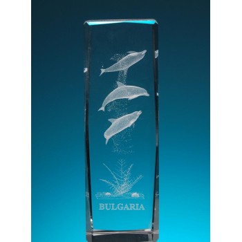 Безцветен стъклен куб с триизмерно гравирани три делфина